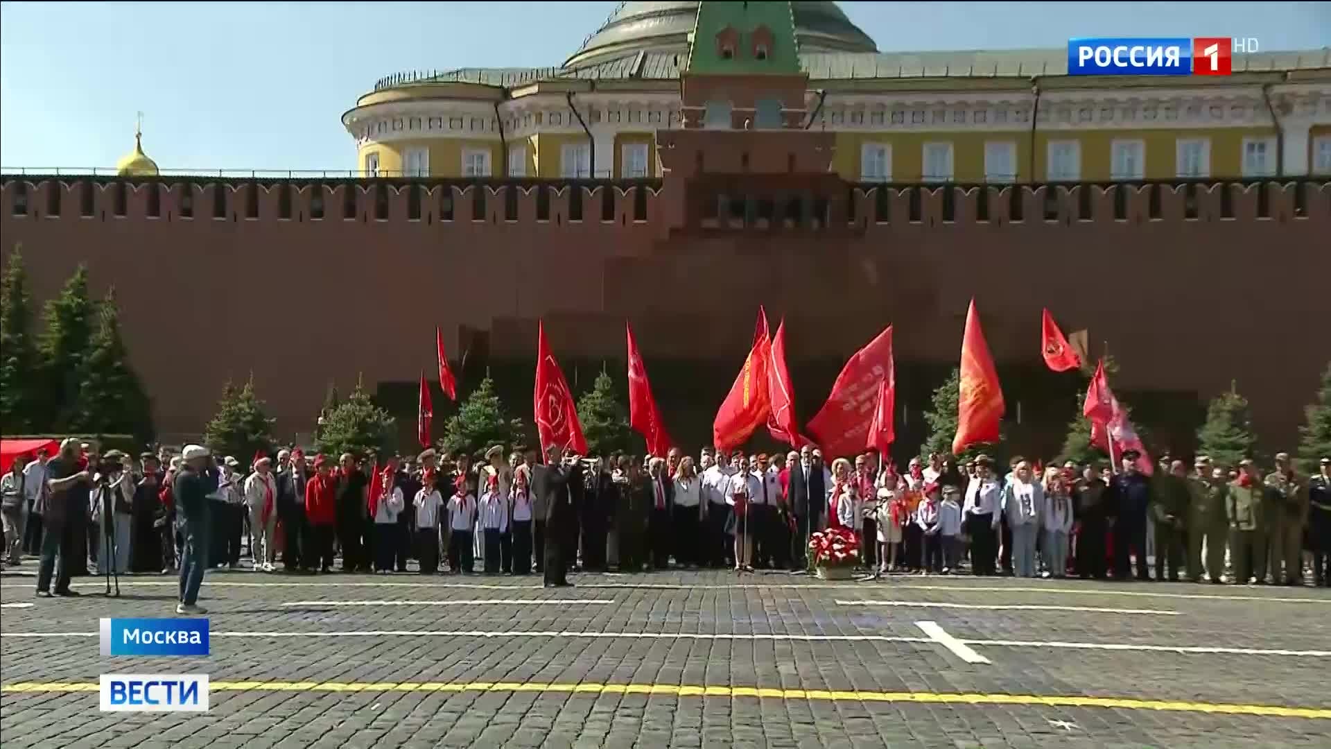 "Школьники из России принимают пионерскую присягу на Красной площади"

или

"Депутаты Госдумы повязывают галстуки пионерам на 104-летии Всесоюзной пионерской организации"